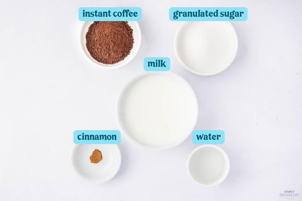 Five white bowls on a white background containing labeled ingredients: instant coffee, granulated sugar, milk, water, and cinnamon. Each ingredient is named with blue text above the bowls.