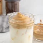 Milk and whipped coffee in a glass canning jar.