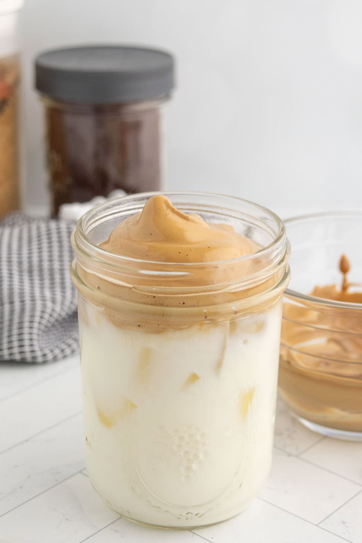Milk and whipped coffee in a glass canning jar.