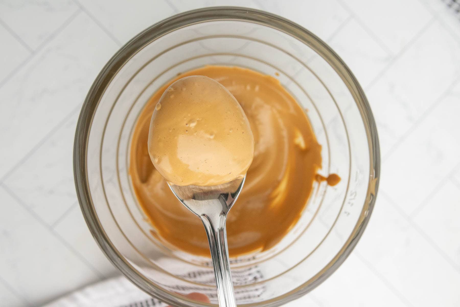 A spoonful of whipped coffee over a bowl.