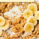 Bowl of banana oatmeal topped with banana slices, a splash of milk, and a sprinkle of cinnamon.