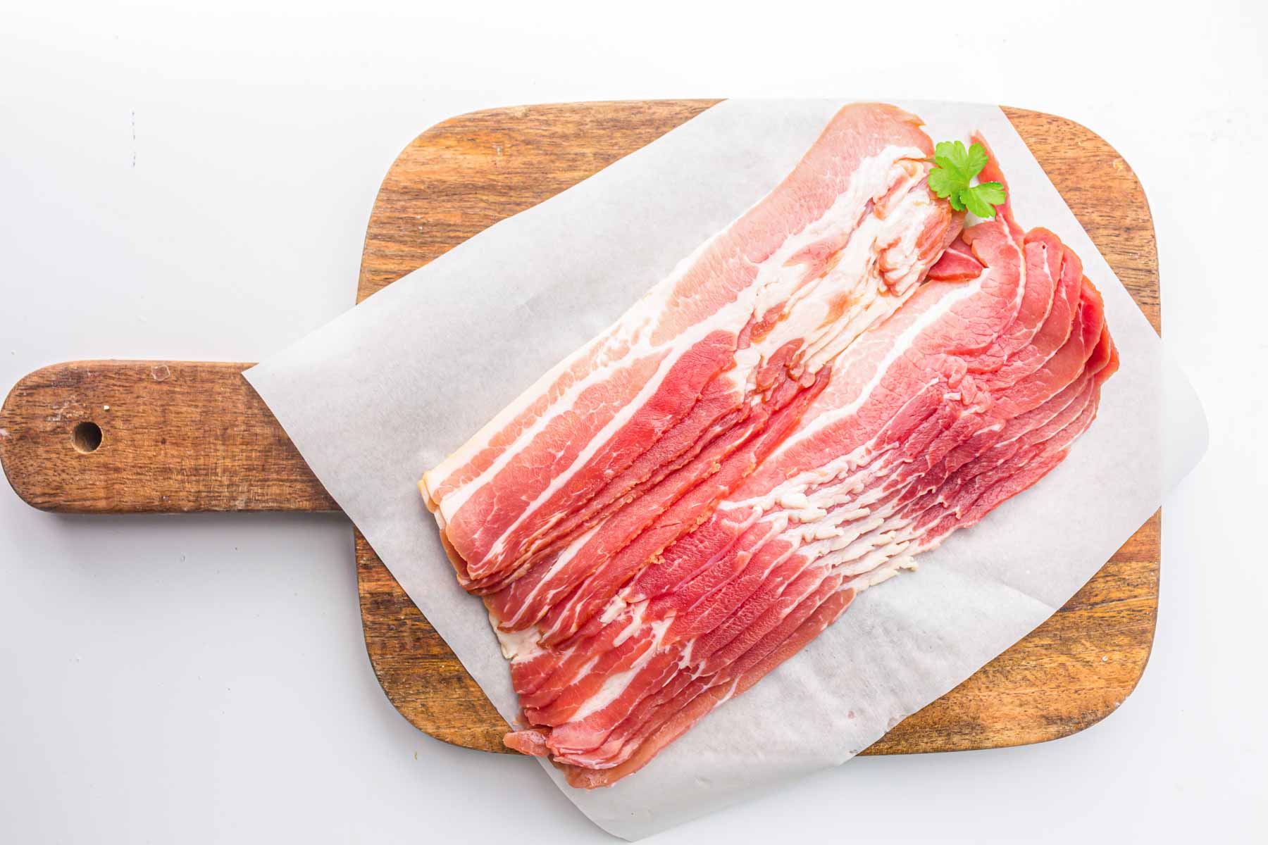 Bacon slices on a wooden cutting board.